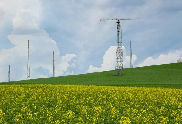 Transmitter tower above a blooming rapeseed field — Stock Photo, Image