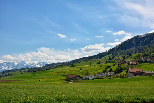Swiss mavi gökyüzü ile bahar mevsiminde kırsal manzara — Stok fotoğraf