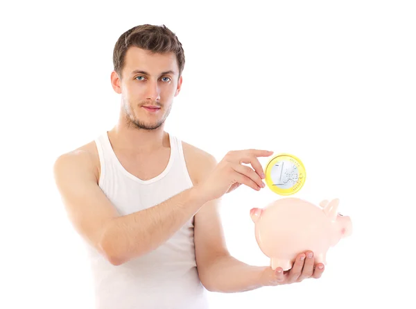 Mooie man holding piggy bank en de euro-munt — Stockfoto