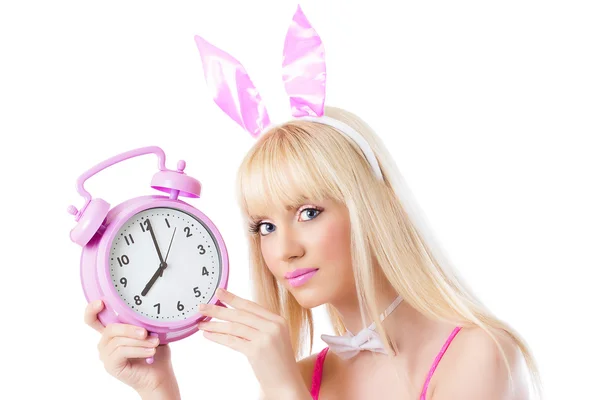 Beautiful girl in bunny ears holding pink clock — Stock Photo, Image