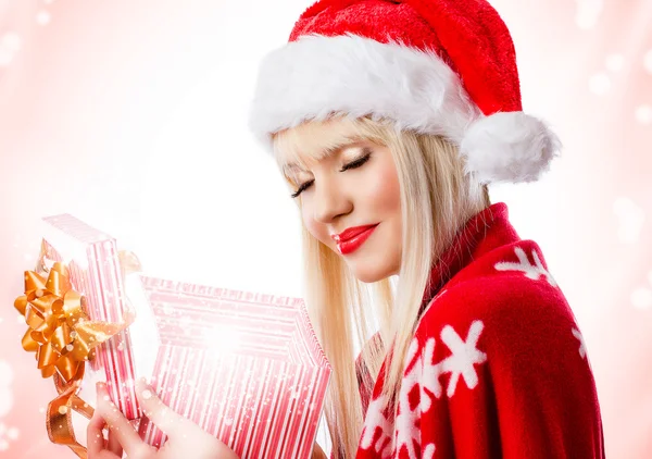 Beautiful blonde young woman in red hat with opened gift box