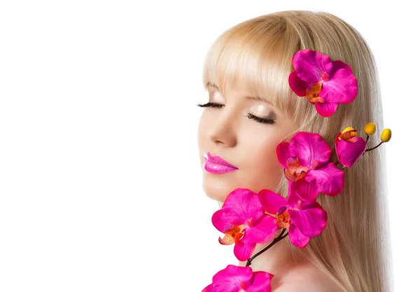 Prachtige blond meisje met orchideebloemen op witte achtergrond — Stockfoto