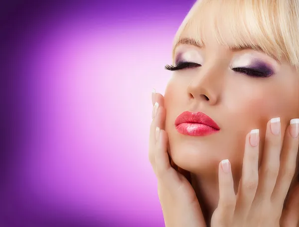 Vacker kvinna med manikyr och lila makeup Stockbild