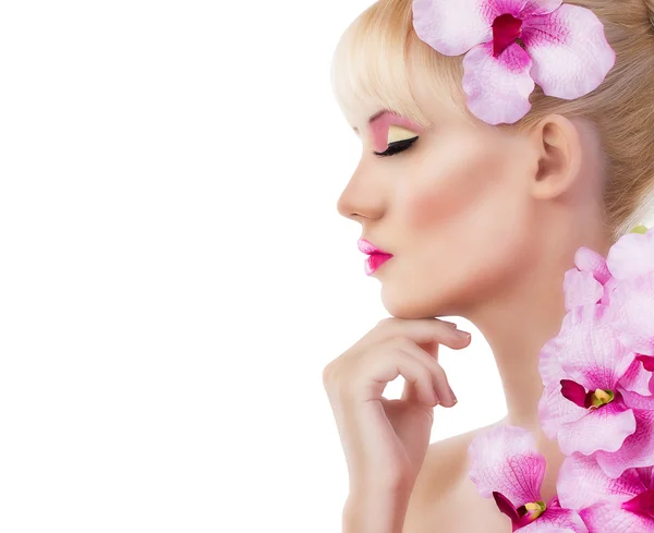 Schöne Frau mit Blumen und rosa Make-up — Stockfoto