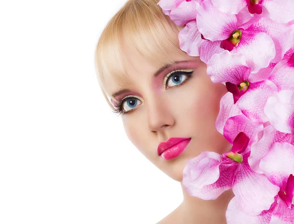 Mooi meisje met bloemen en roze make-up — Stockfoto