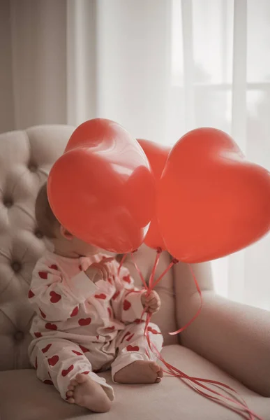 Hermosa Niña Sentada Una Silla Sosteniendo Globos Corazón —  Fotos de Stock