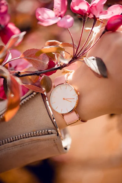 Stylish white watch on woman hand.