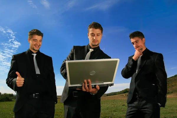 ノート パソコンを見ているビジネスの男性のグループ — ストック写真