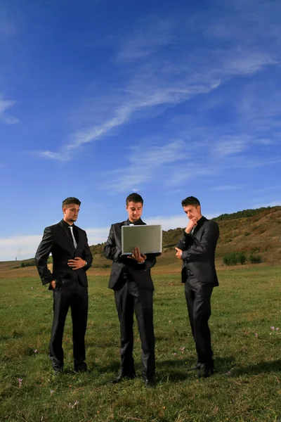 ノート パソコンを見ているビジネスの男性のグループ — ストック写真