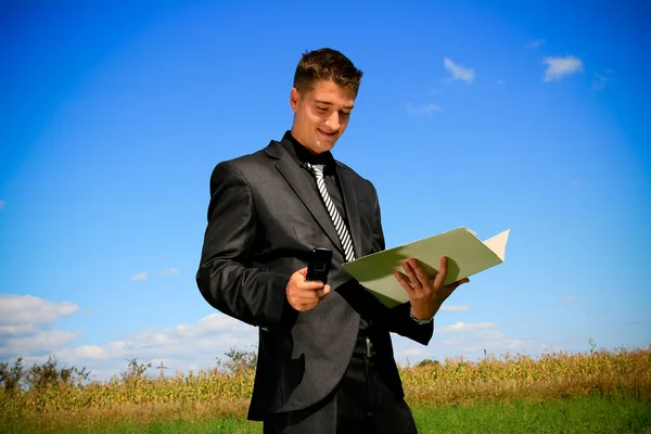 Zakenman met map en cellphone — Stockfoto