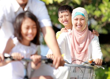 Gelukkig moslim familie paardrijden fietsen