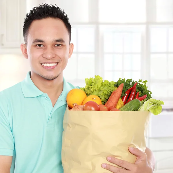 Uomo in possesso di shopping bag pieno di generi alimentari — Foto Stock
