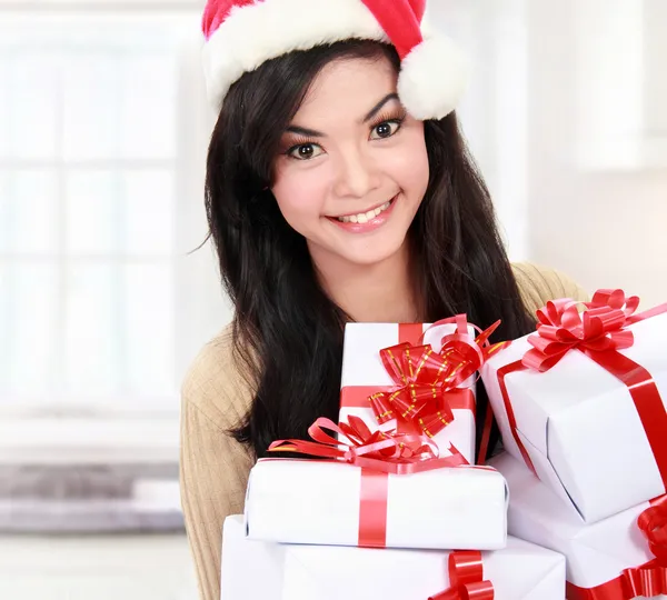 Frau mit Weihnachtsmütze hält Weihnachtsgeschenke in der Hand — Stockfoto