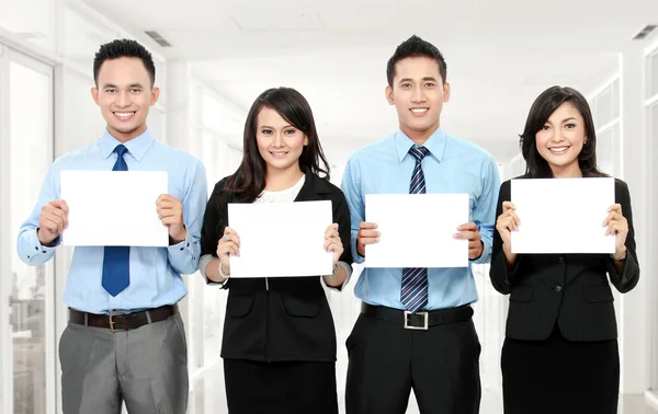 Equipo empresarial sosteniendo papel en blanco — Foto de Stock