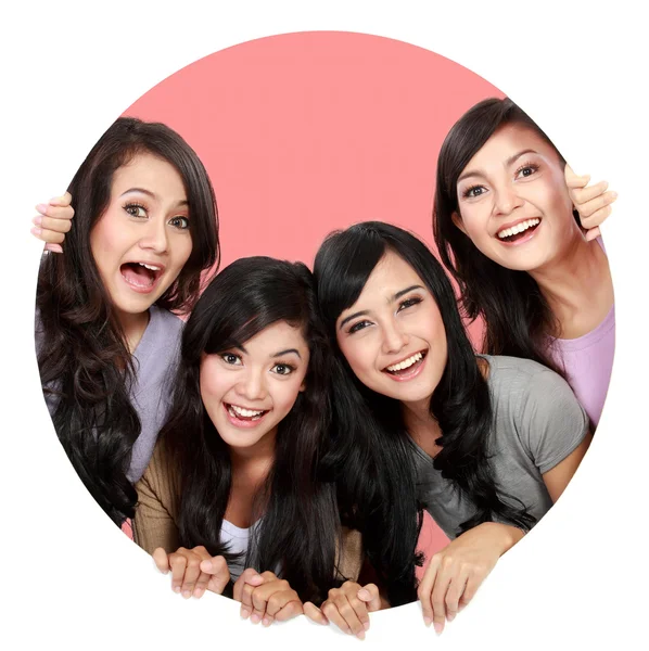 Group of beautiful women smiling peeping through circle hole — Stock Photo, Image