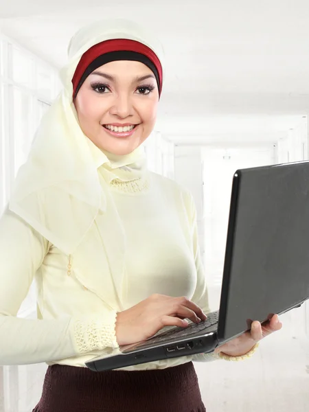 Asian young muslim woman in head scarf using laptop — Stock Photo, Image