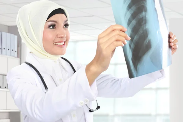 Sorrindo asiático médico médico olhando para xray — Fotografia de Stock