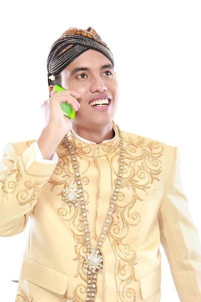 Człowiek z garnitur tradycyjnych java przy użyciu telefonu komórkowego — Zdjęcie stockowe