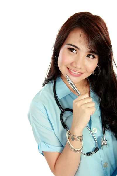 Felice giovane infermiera con stetoscopio e pensiero — Foto Stock