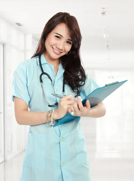 Mujeres médicas sonriendo y sujetando el portapapeles —  Fotos de Stock