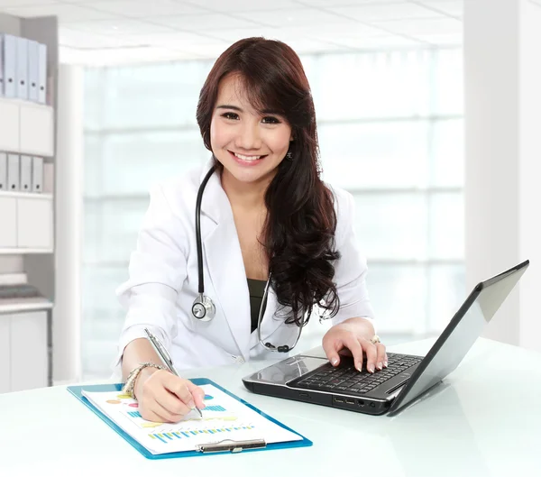 Χαμογελώντας γιατρός γυναίκες εργάζονται στο γραφείο της — Φωτογραφία Αρχείου