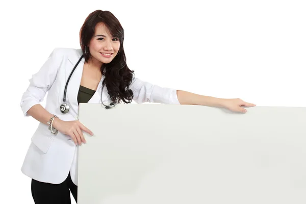 Smiling female young doctor holding blank white board — Stock Photo, Image