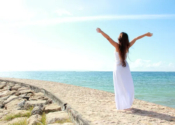 Frau entspannt sich mit offenen Armen am Strand und genießt ihre Freiheit — Stockfoto