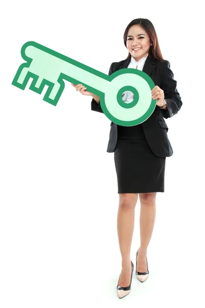 Businesswoman holding sign of key — Stock Photo, Image