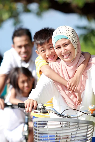 Портрет счастливой мусульманской семьи, катающейся на велосипедах вместе — стоковое фото