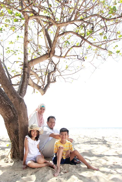 Sonriendo feliz familia relajándose en la playa — Foto de Stock