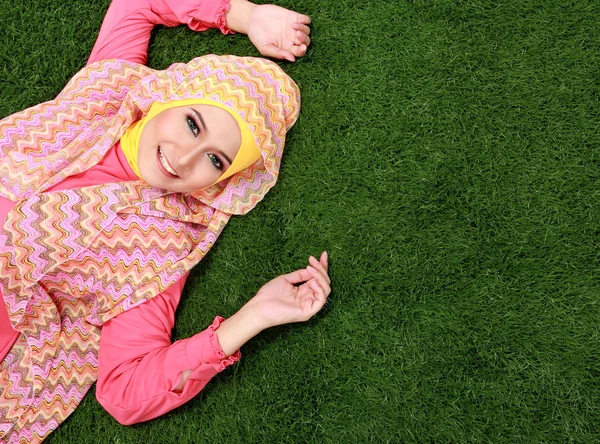 Gadis muslim muda berbaring di rumput — Stok Foto