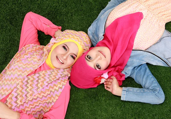 Dwa muzułmańska kobieta, leżąc na trawie — Zdjęcie stockowe