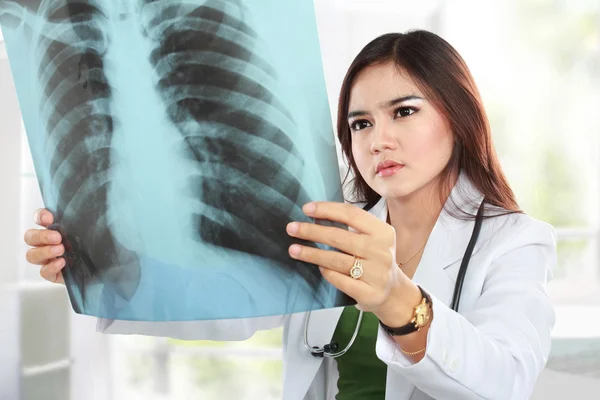 Médico asiático lleva una bata blanca y estetoscopio mirando a un — Foto de Stock