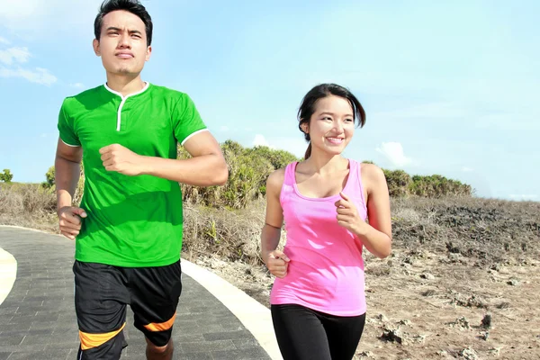 Jovem casal correndo juntos na pista de corrida — Fotografia de Stock