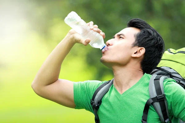 Homem sedento bebendo uma garrafa de água — Fotografia de Stock