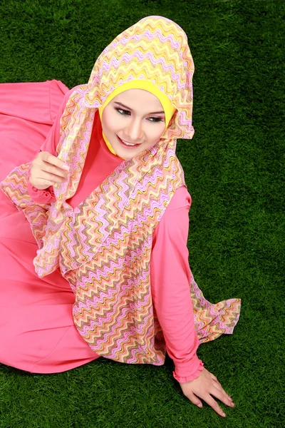 Chica musulmana joven usando hijab sentado en la hierba — Foto de Stock