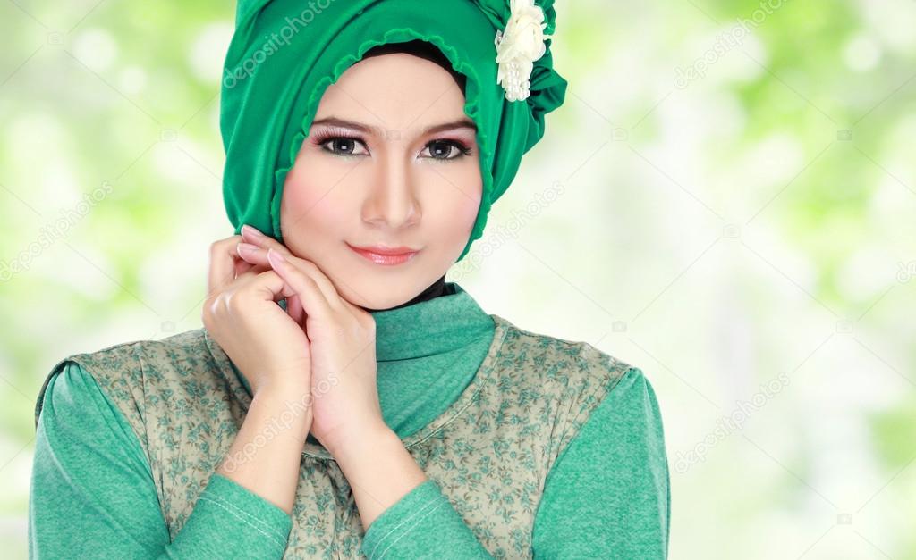 Young happy beautiful muslim woman with green costume wearing hi