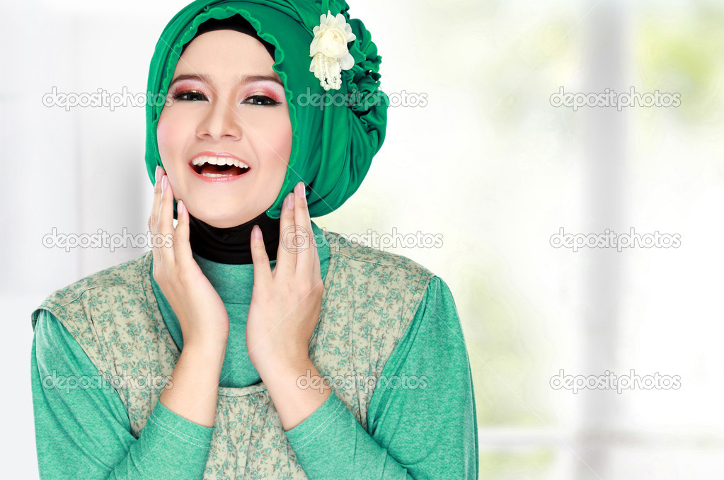 Young happy beautiful muslim woman with green costume wearing hi