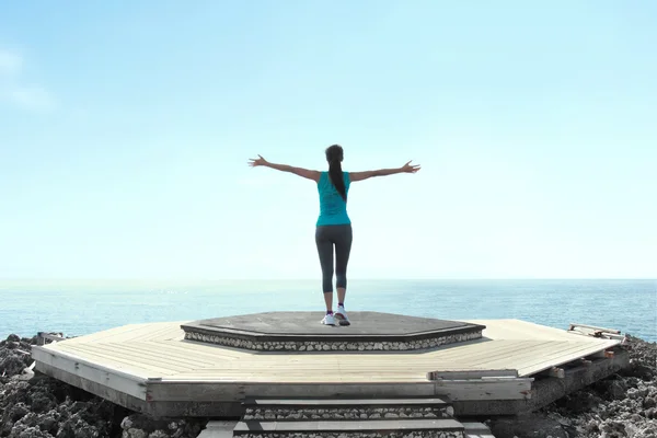 Mujer libre levantando brazos para despejar el cielo azul — Foto de Stock