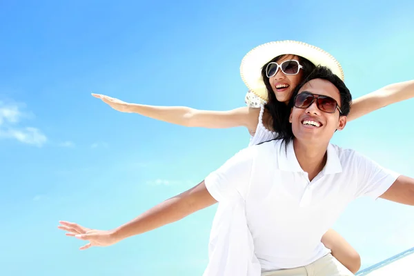 Feliz sonriente pareja de verano a cuestas junto con los brazos outstre —  Fotos de Stock