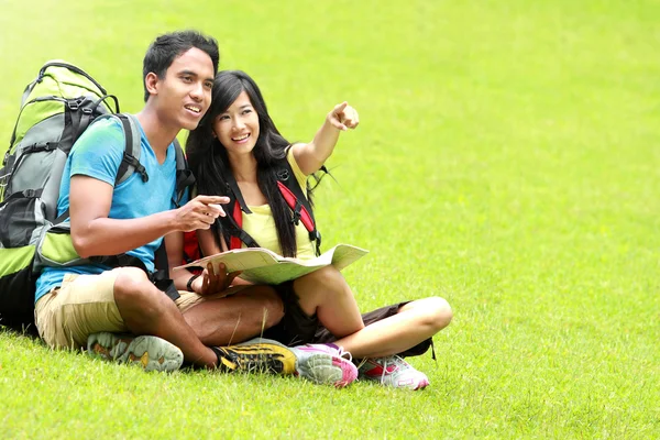 Young couple tourist read the map and show the direction