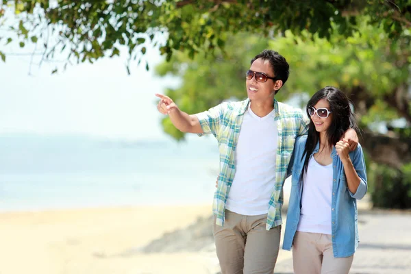 Feliz casal andando pela praia juntos no amor segurando em torno de cada outro — Fotografia de Stock