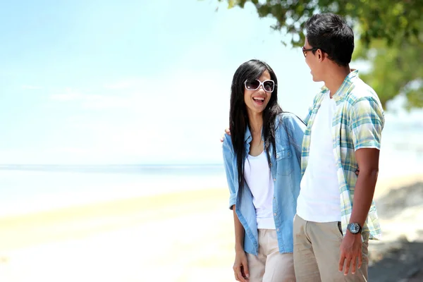 Gelukkige paar wandelen aan het strand samen in liefde houden om elkaar heen — Stockfoto