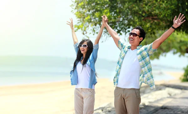 Portrait of young couple standing and raised their hands — Stock Photo, Image