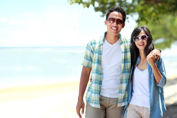 Pareja feliz caminando por la playa juntos en el amor sosteniéndose el uno al otro —  Fotos de Stock