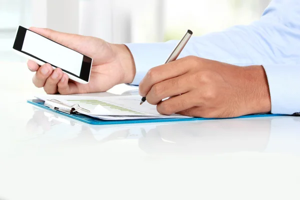 Affärsman handen håller smarta mobiltelefon med blank skärm — Stockfoto