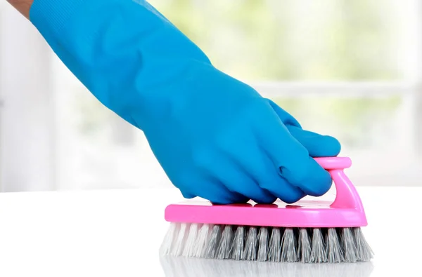 Hand with glove using cleaning brush to clean up — Stock Photo, Image