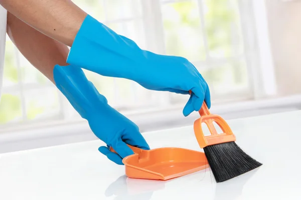 Hand with glove using cleaning broom to clean up — Stock Photo, Image