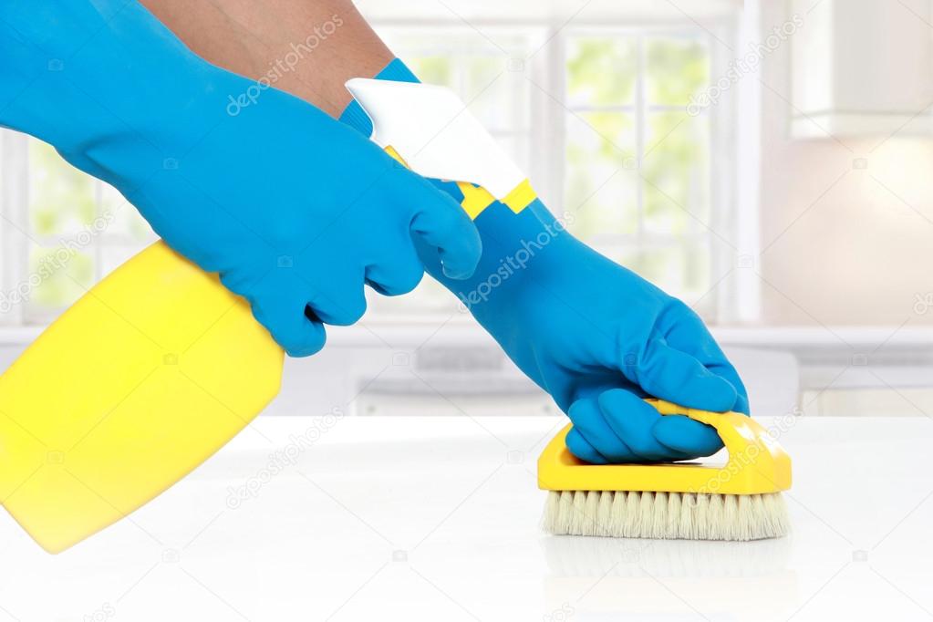hand with glove using cleaning brush to clean up