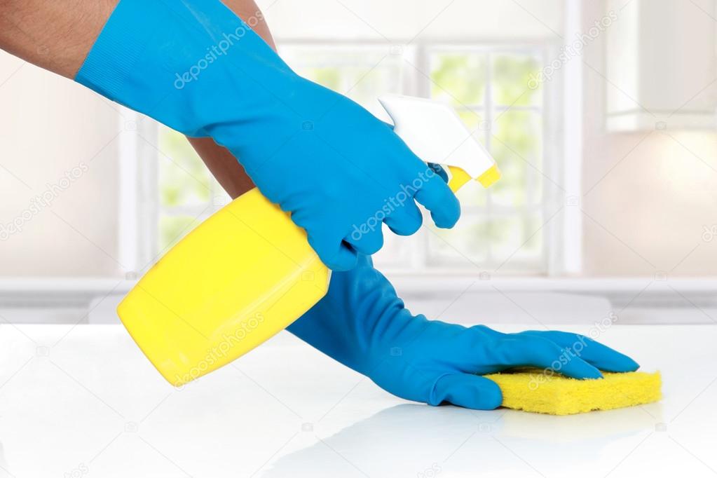 hand with glove using cleaning sponge to clean up